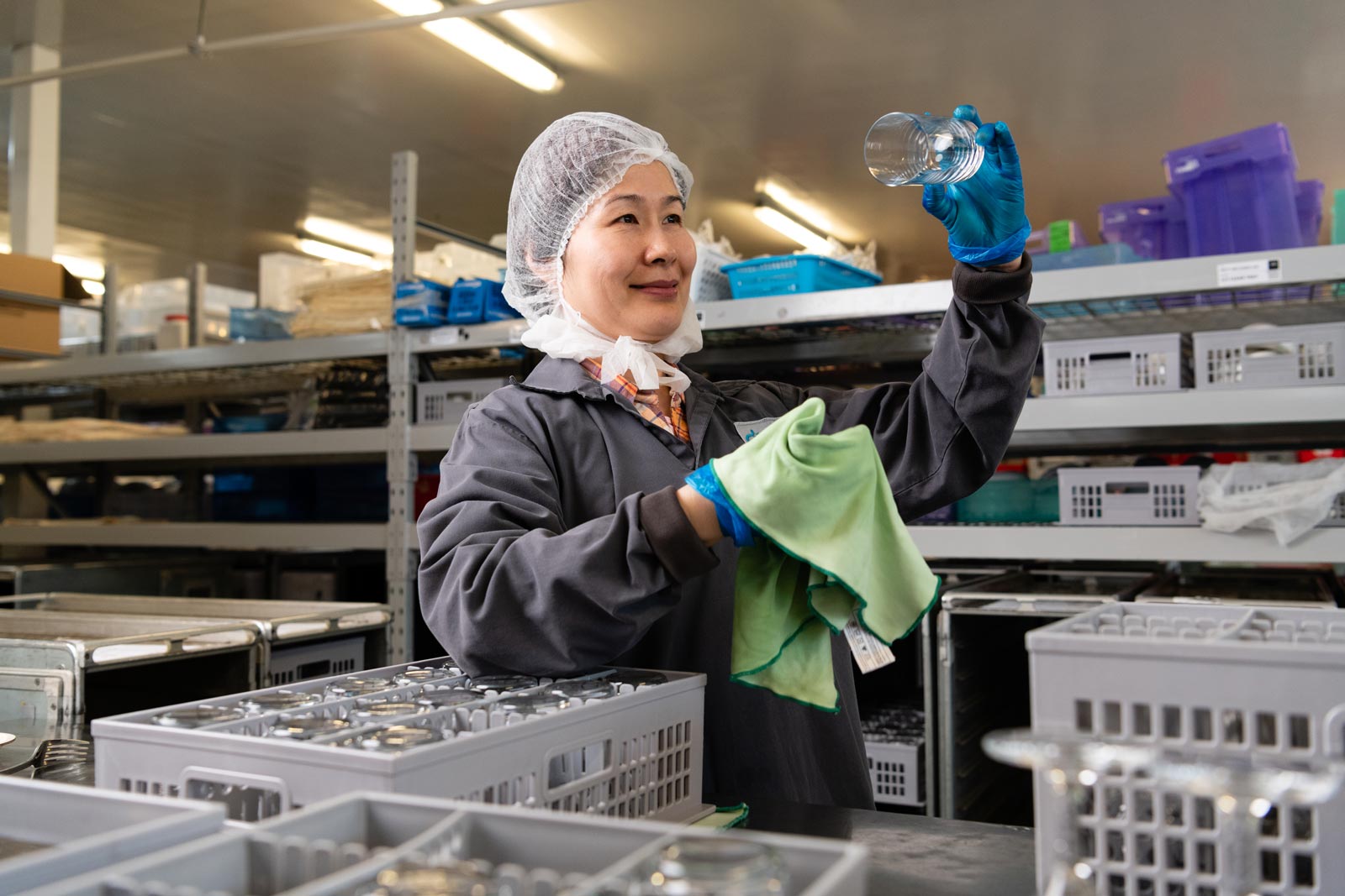 Jie meticulously polishes glasses and rolls the cutlery for Business Class